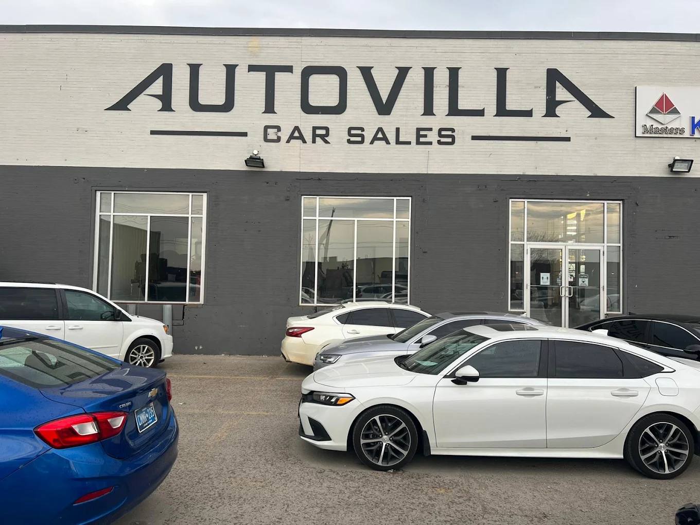 Large dark Autovilla Car Sales dimensional letters on a painted brick building