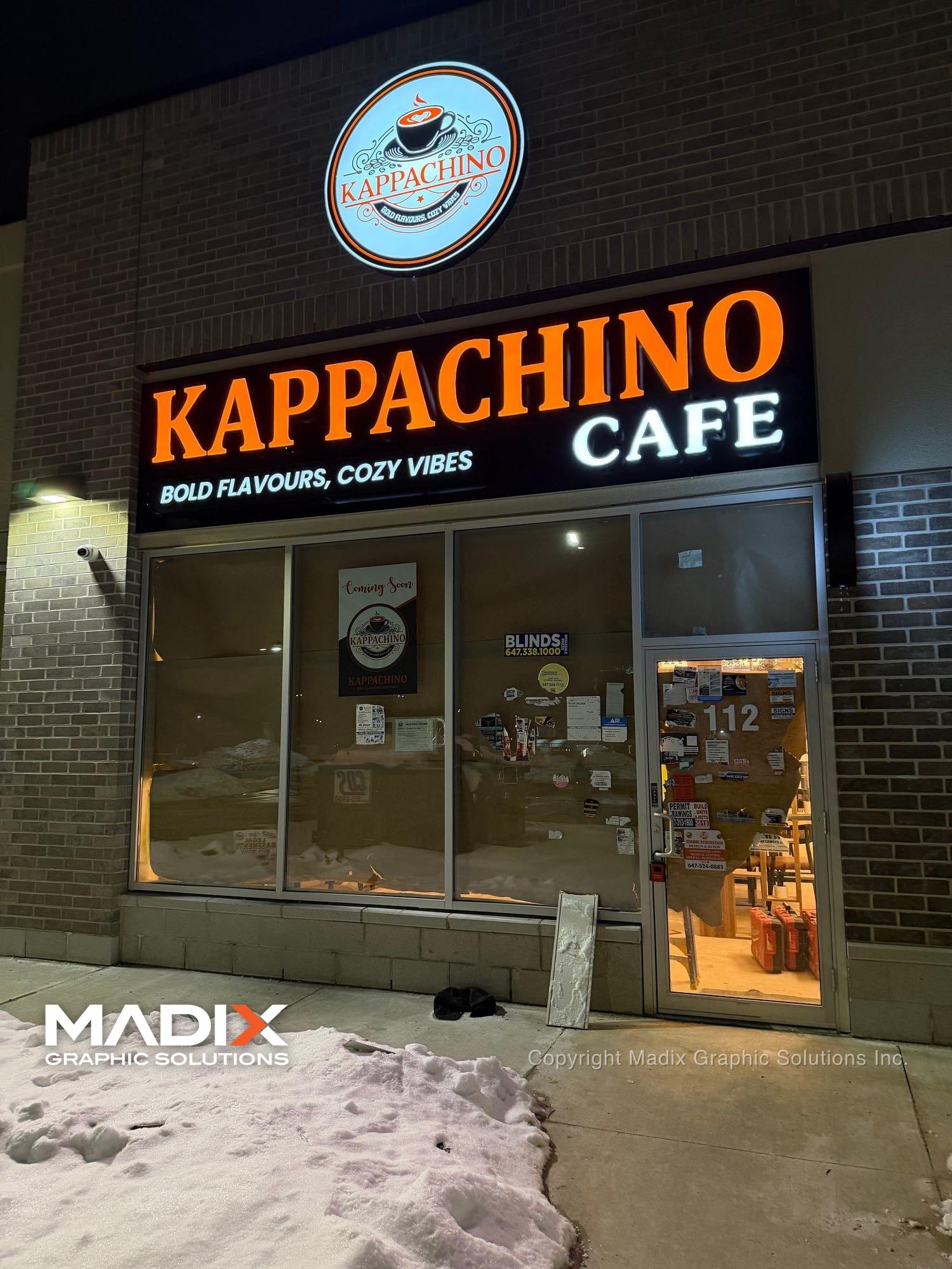 Illuminated channel letter sign on a café at night