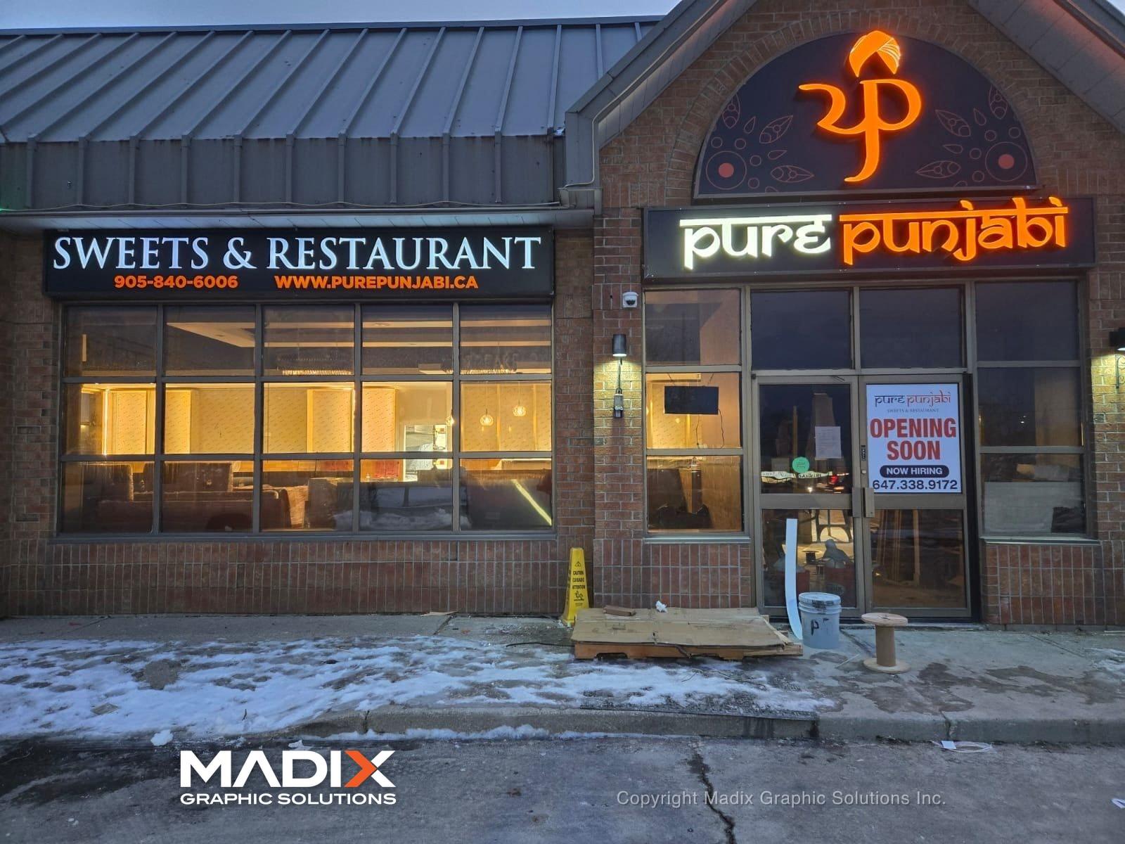 Illuminated channel letters on a plaza restaurant at night