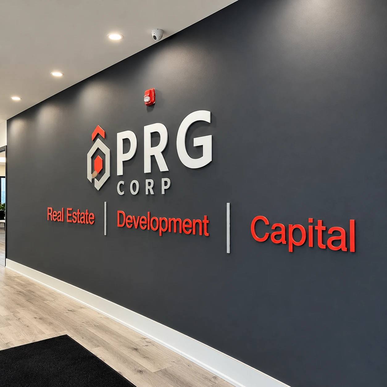 Dimensional logo and red lettering on a dark grey office lobby wall