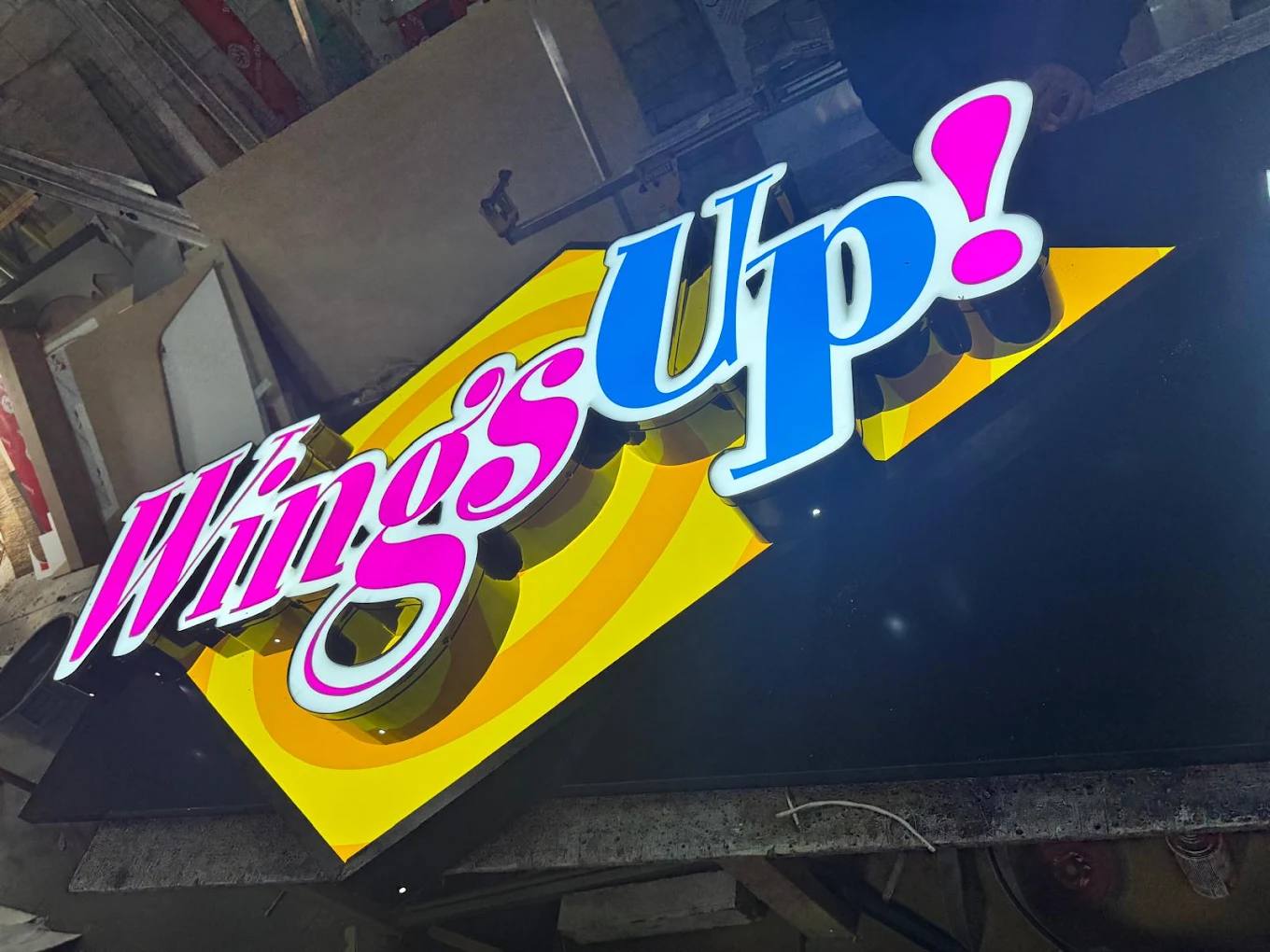 Wings Up illuminated channel letter sign lit up during fabrication